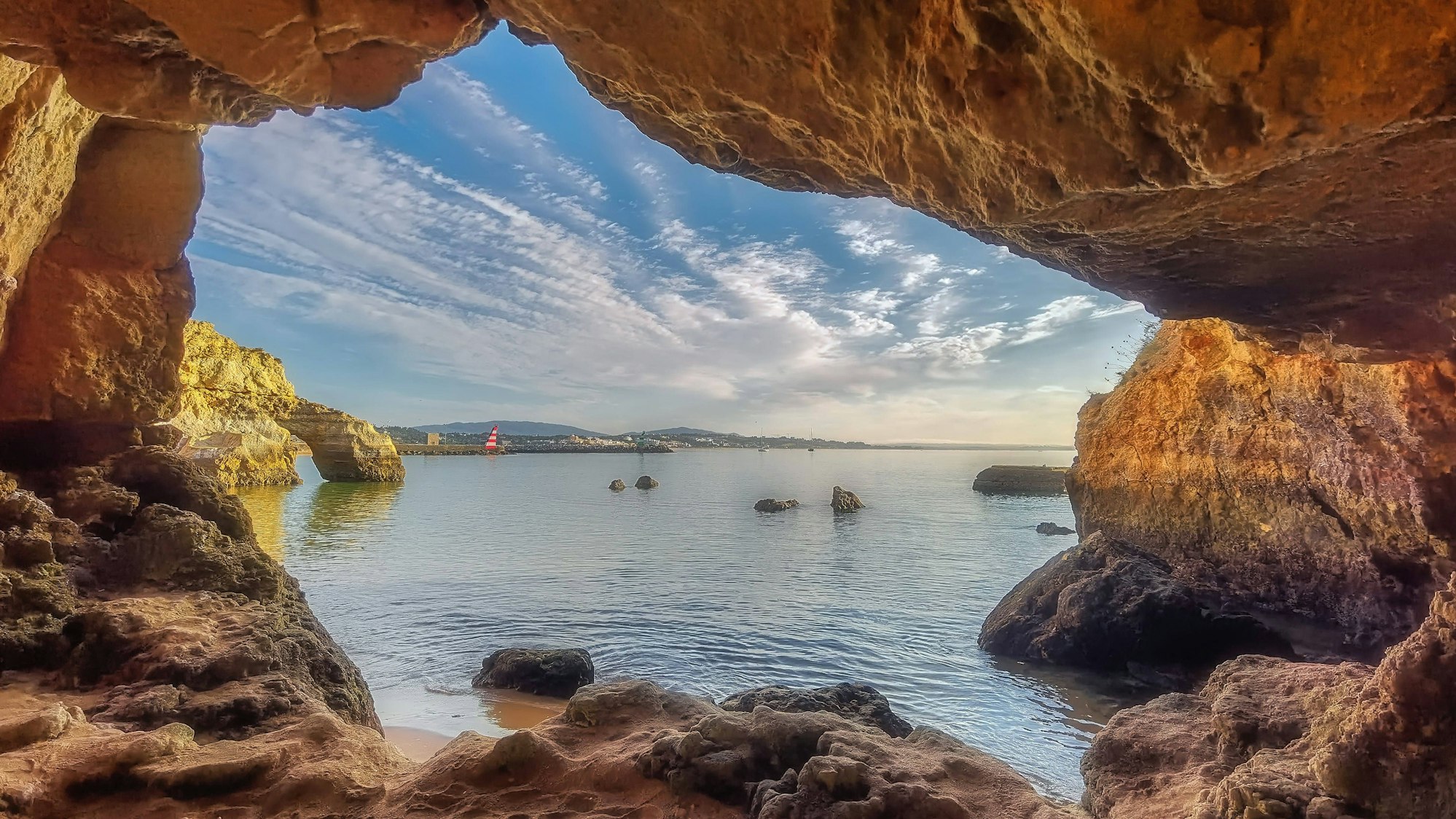 Morgensonne an der Algarve – durch das Felsenfenster von Praia da Balança zeigt sich Portugal von seiner friedlichsten Seite.