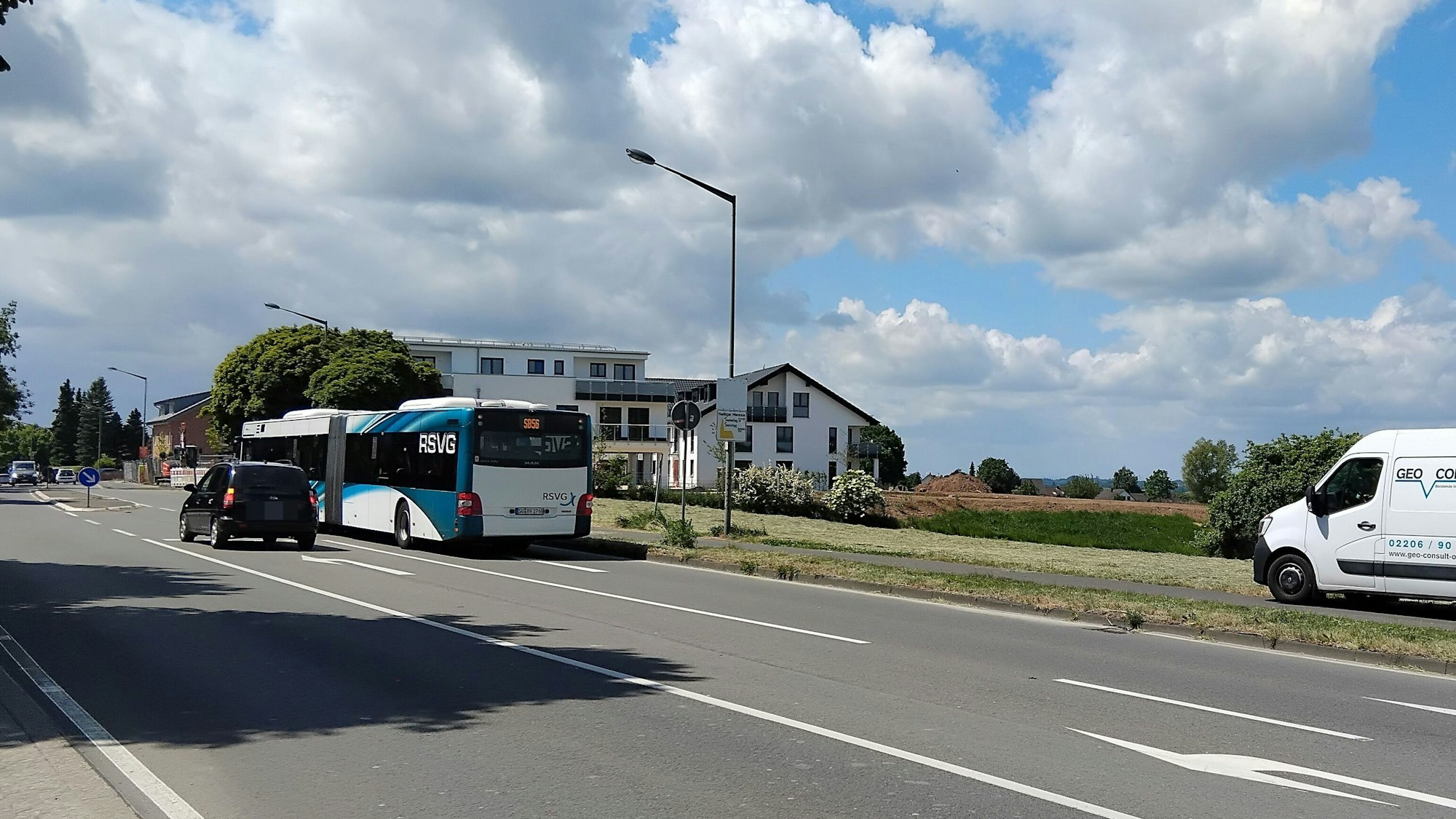 Eine breite Straße, Ortsrandbebauung und freies Feld