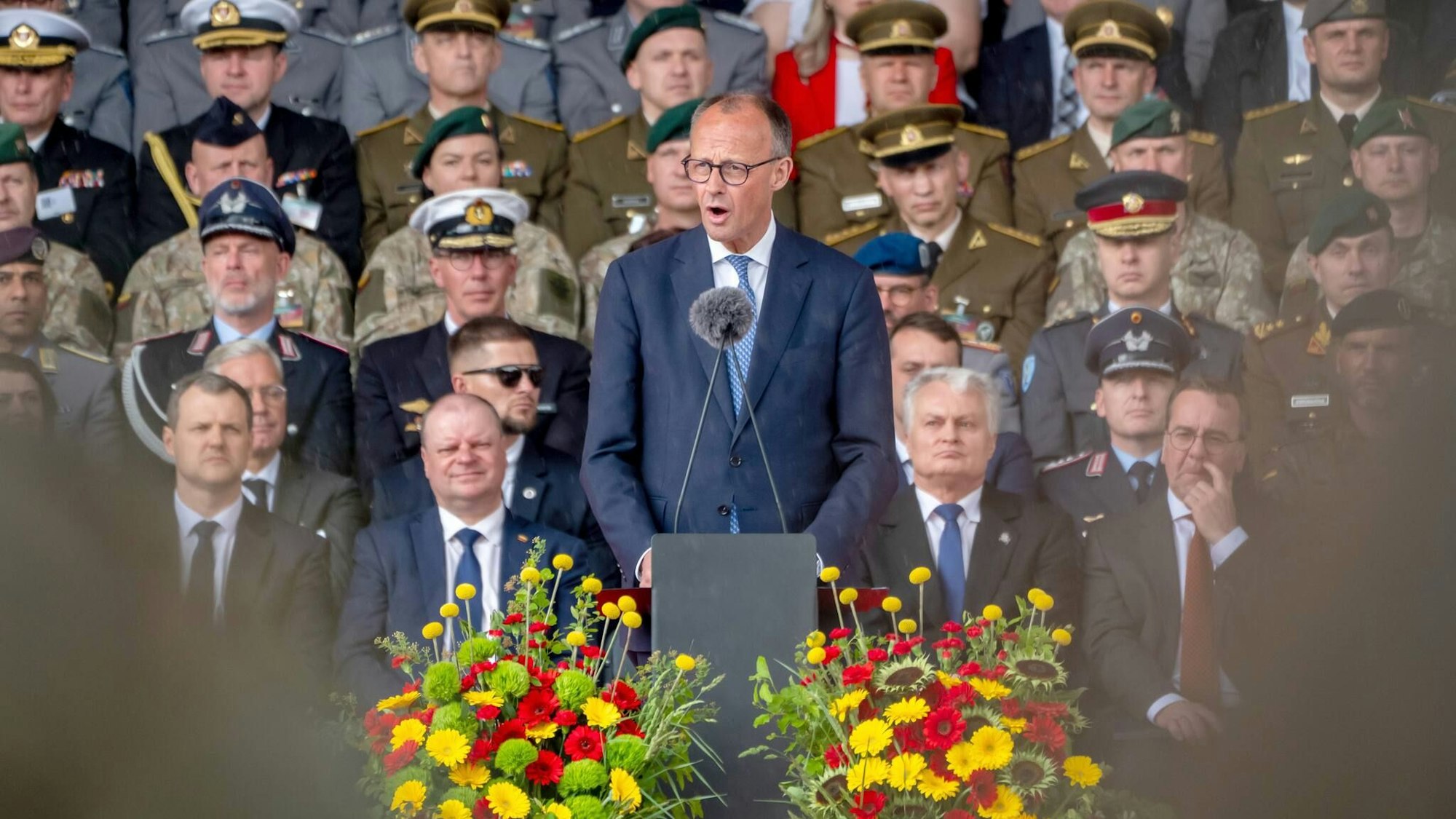 Bundeskanzler Friedrich Merz (CDU) spricht beim Aufstellungsappell der Panzerbrigade 45. Hinter ihm sitzen der litauische Präsident Gitanas Nauseda (2.v.r.) und Verteidigungsminister Boris Pistorius (SPD, r). Die Panzerbrigade 45 der Bundeswehr ist dauerhaft in Litauen stationiert und soll die Ostflanke der Nato unterstützen. .