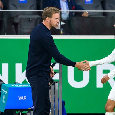 Bundestrainer Julian Nagelsmann (l) klatscht mit Deutschlands Jamal Musiala (r) nach der Auswechslung ab.