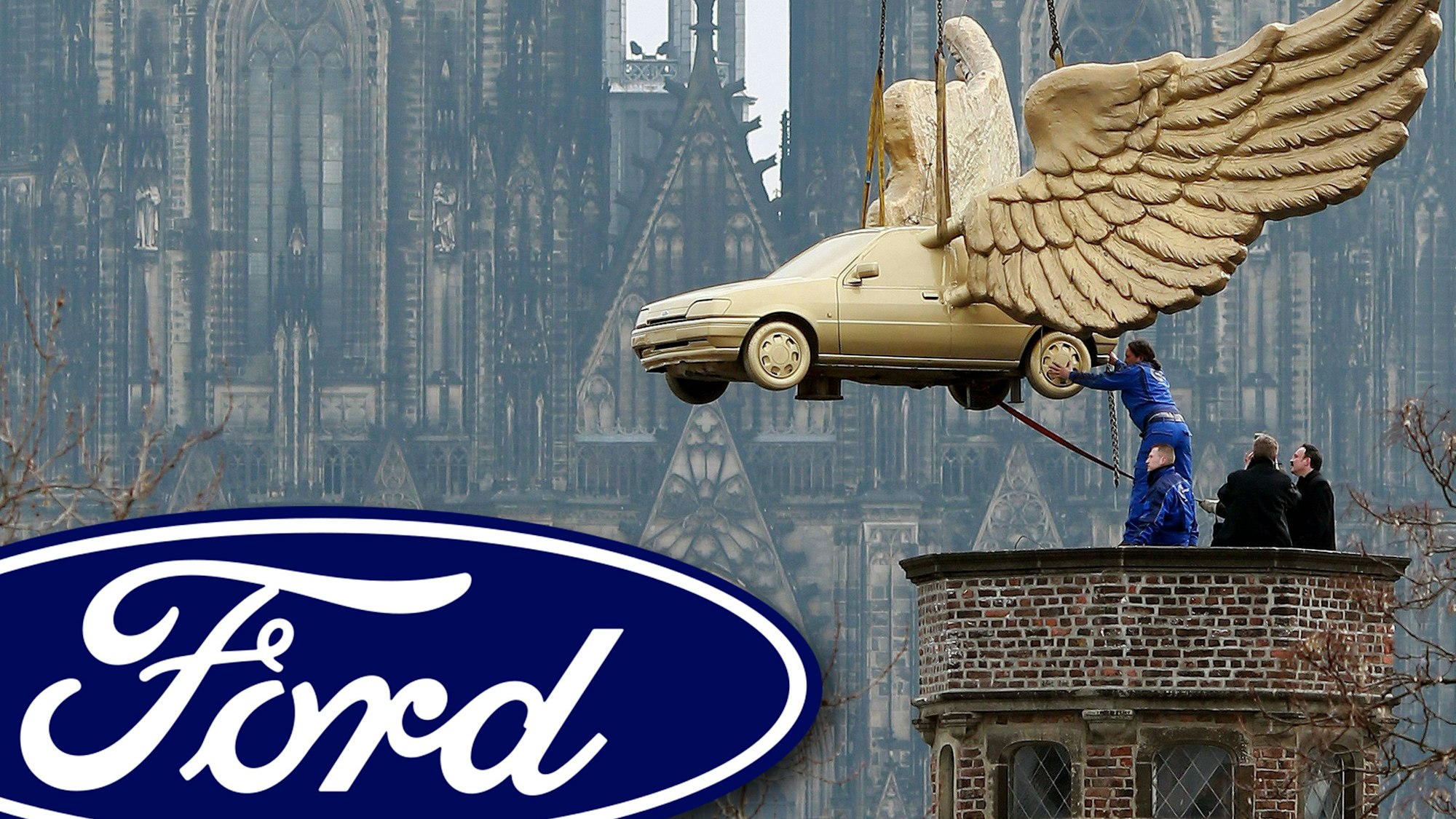 Das Flügelauto (Ford Fiesta) des Aktionskünstlers HA Schult hängt an einem Kran