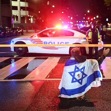 Ein Mann, der die israelische Flagge mit einem Kreuz und dem Namen „Jesus“ in der Mitte trägt, gestikuliert, während Beamte der Metropolitan Police das Gebiet sichern