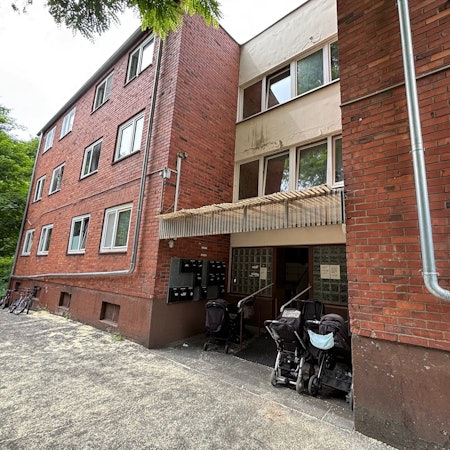 Auf dem Bild ist ein altes Backsteingebäude zu sehen, das als städtische Unterkunft dient.