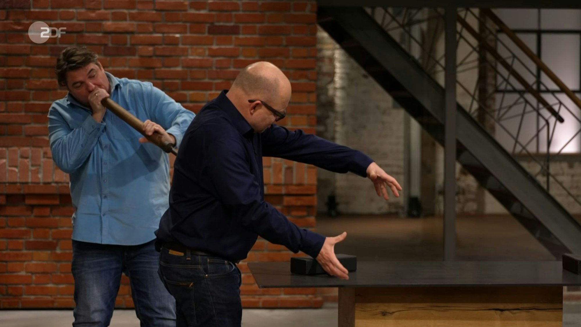 Comedy im Händlerraum: Daniel Meyer und Benjamin Leo Leo stellen pantomimisch die Funktionsweise der Glasmacherpfeife von Rainhard und Gerlinde dar. Den Wunschpreis von 50 Euro erhöhte Colmar Schulte-Goltz auf bis zu 200. Meyer bezahlte 250 Euro. (Bild: ZDF)