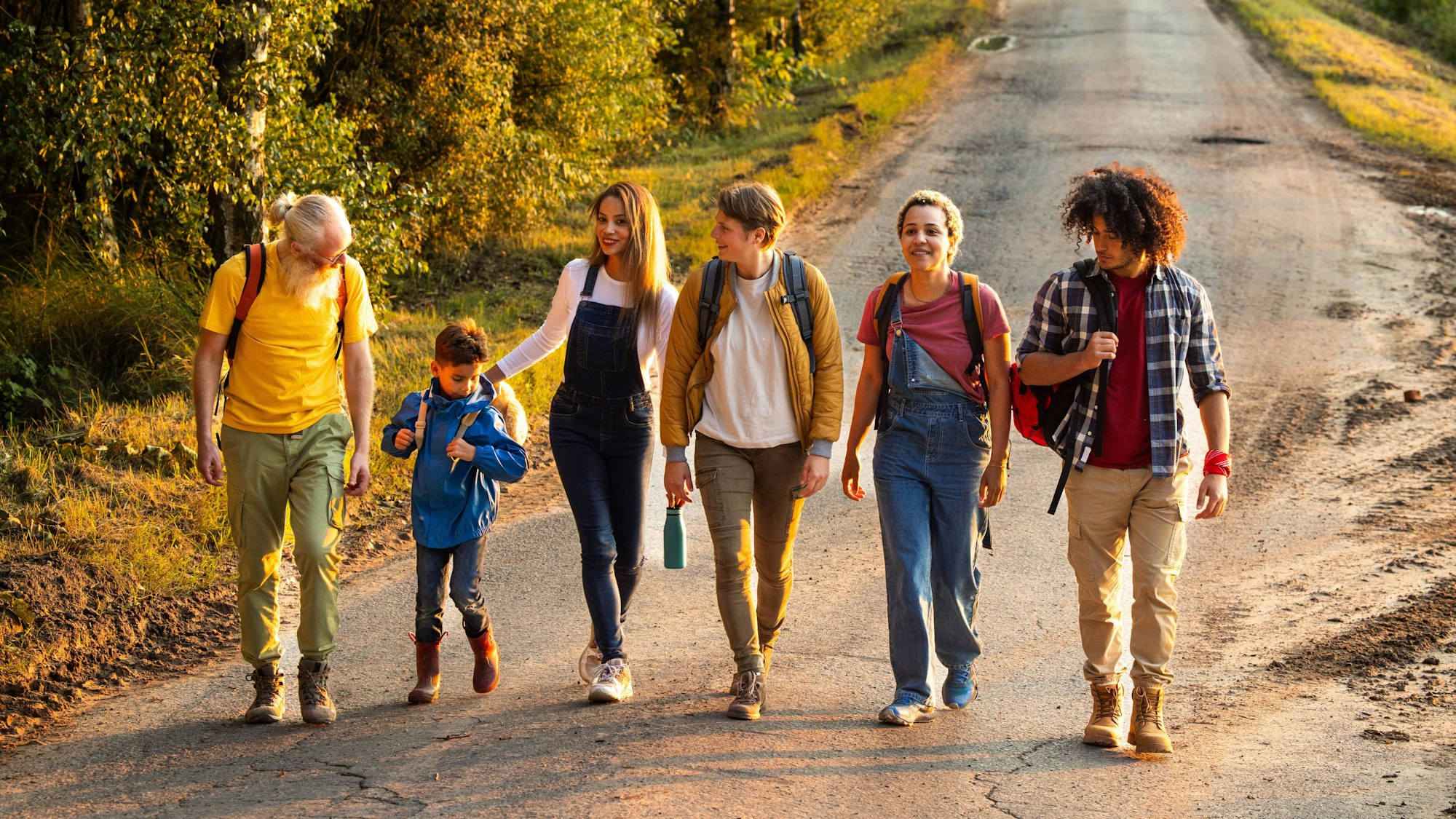 Freunde spazieren durch eine schöne, ländliche Naturlandschaft hinter dem Dorf.