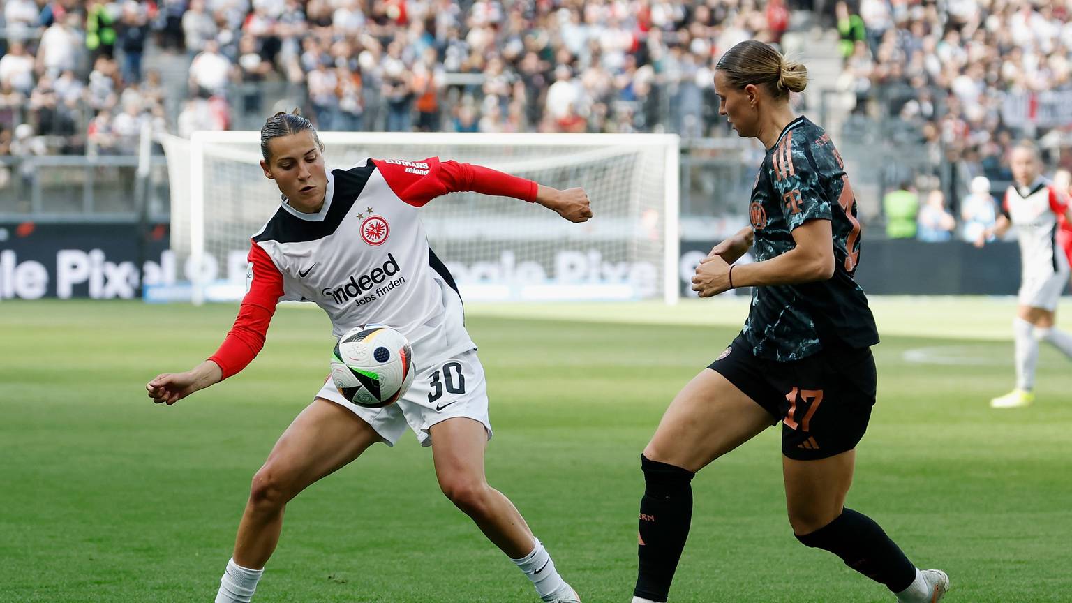 ARCHIV - 12.04.2025, Hessen, Frankfurt/M.: Fußball, Frauen: Bundesliga, Eintracht Frankfurt - Bayern München, 19. Spieltag, Deutsche Bank Park. Carlotta Wamser (Eintracht Frankfurt, 30) l. versucht sich gegen Klara Buehl (FC Bayern Muenchen, 17) durchzusetzten. (zu dpa: «Eintracht-Fußballerinnen mit drei weiteren Abgängen») Foto: Heiko Becker/dpa +++ dpa-Bildfunk +++