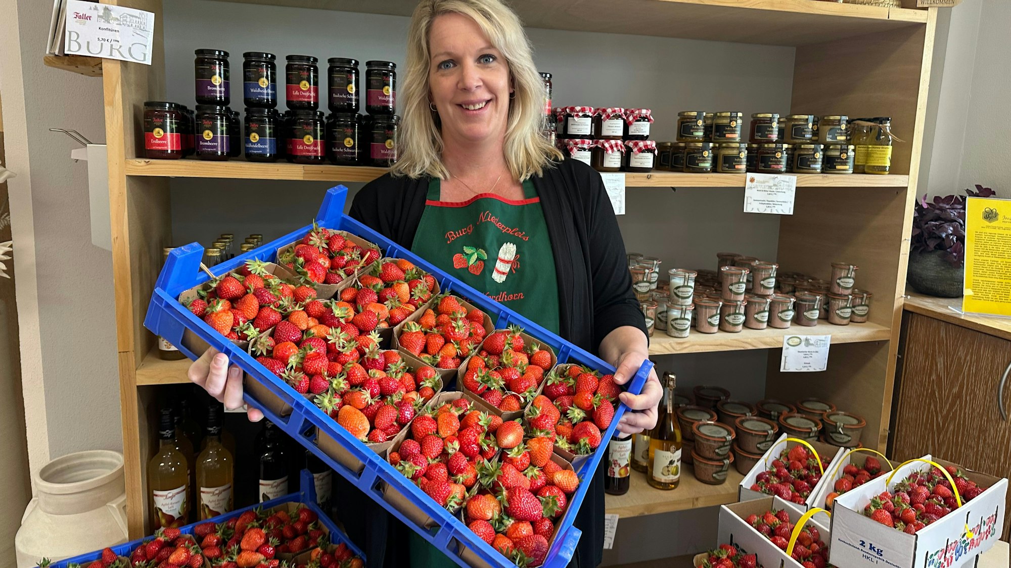 Verena Nordhorn verkauft Erdbeeren im Hofladen der Burg Niederpleis