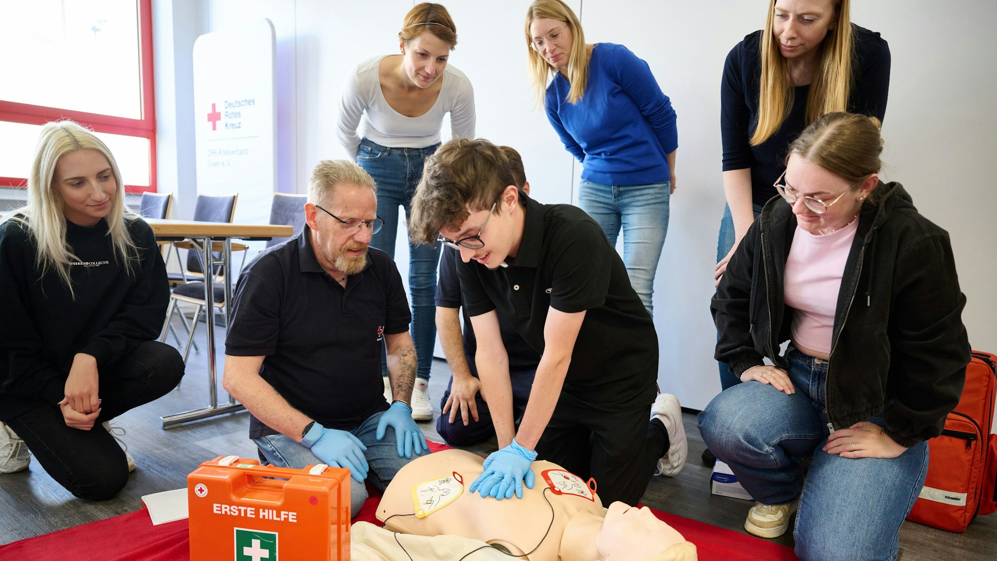 Essen: Detlef Zabel (2.v.l.), Referatsleiter Erste Hilfe-Ausbildung beim DRK-Kreisverband Essen, leitet den Auszubildenen Moritz Pohl (M) bei einer Übung zur Reanimation mit Hilfe eines Defibrillator an. (zu dpa: «Wie oft die Bundesbürger einen Erste-Hilfe-Kurs besuchen»)