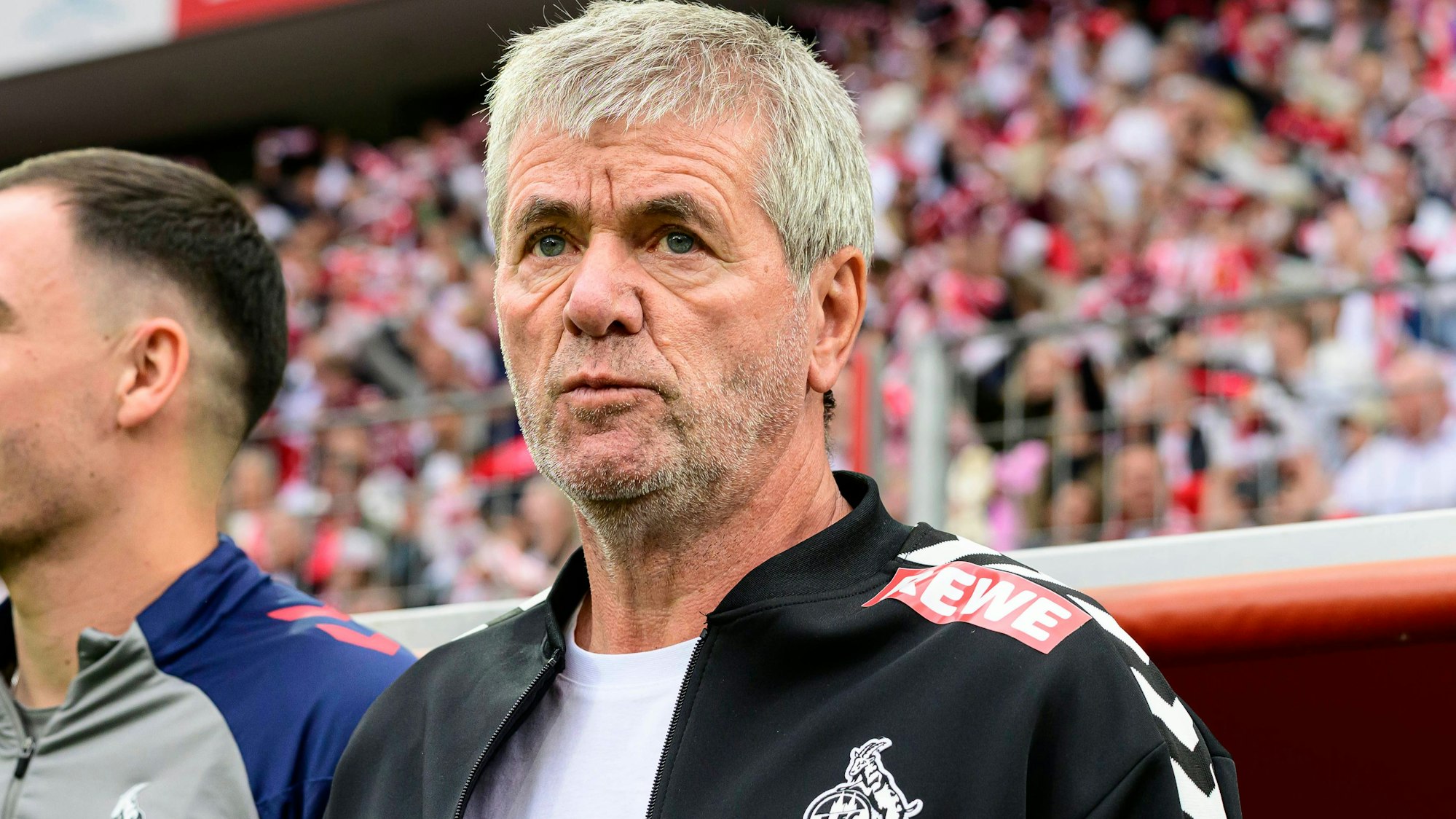 Friedhelm Funkel steht vor einem FC-Spiel vor der Trainerbank.