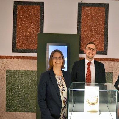 Dr. Silva Bruder, Dustin Hoferichter und Lisa Kröger stehen hinter einer Vitrine.