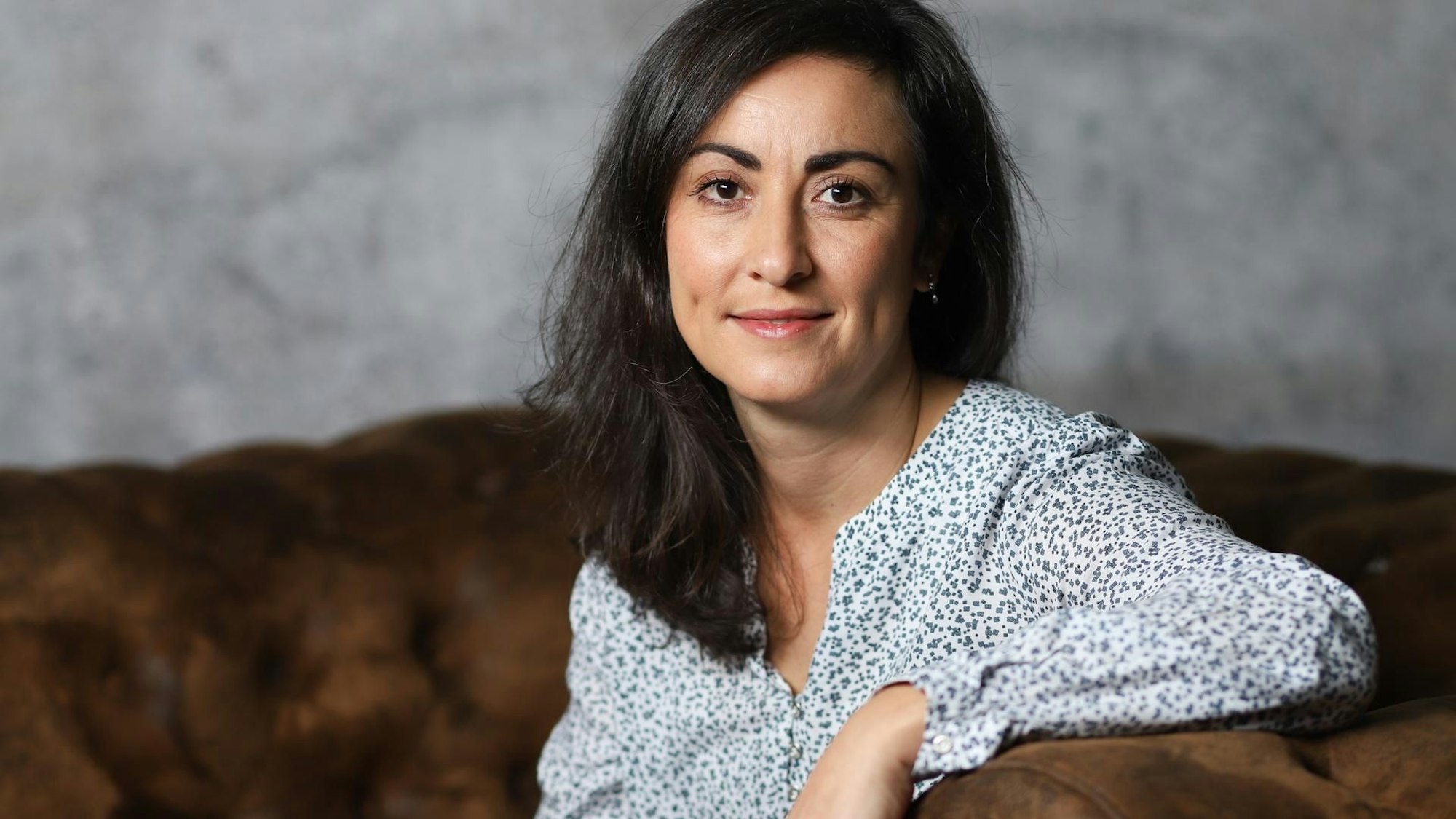 Eine Frau sitzt auf einem Sofa.