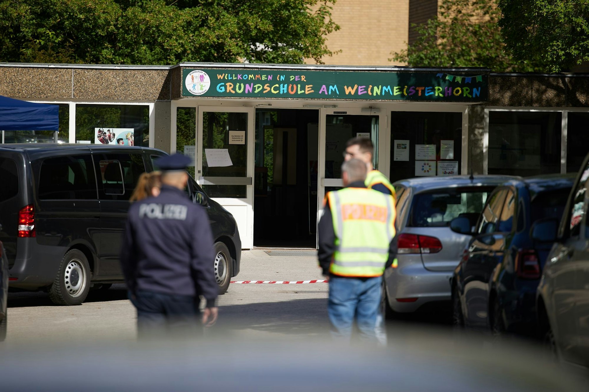 Polizisten stehen vor einer Schule im Berliner Bezirk Spandau, an der es am Vormittag einen möglichen Messerangriff auf einen Schüler gab.