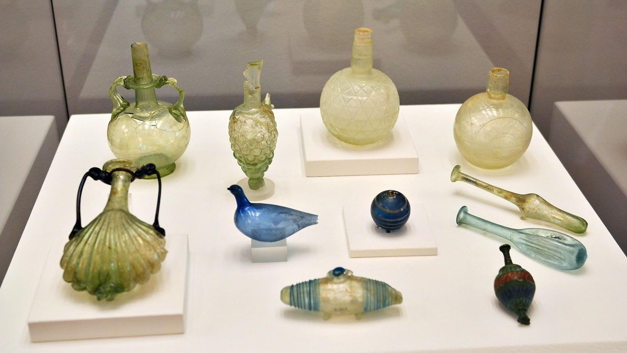 Antike Luxusgüter wie aufwändig gestaltete Parfümfläschchen sind in einer Vitrine ausgestellt.