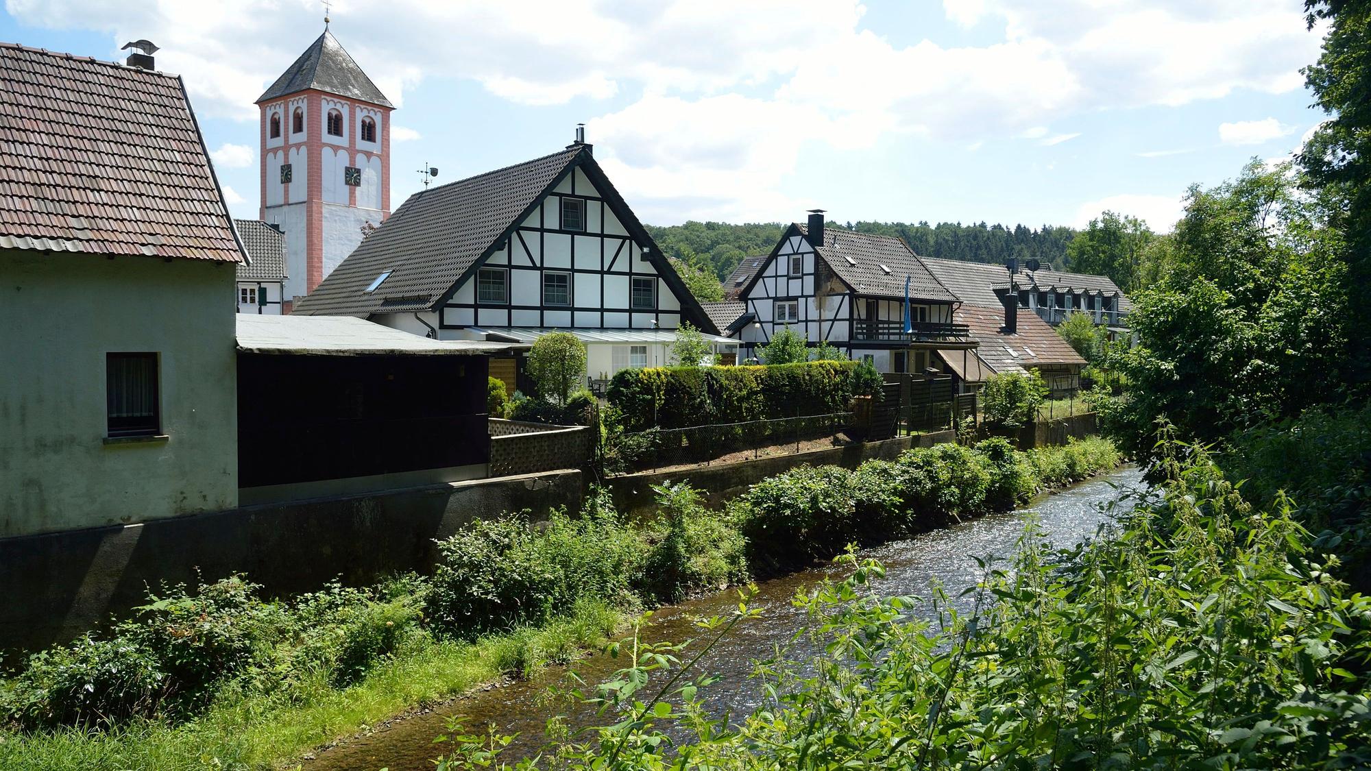 Odenthal mit Kirche und Fachwerkhäusern, im Vordergrund die Dhünn.