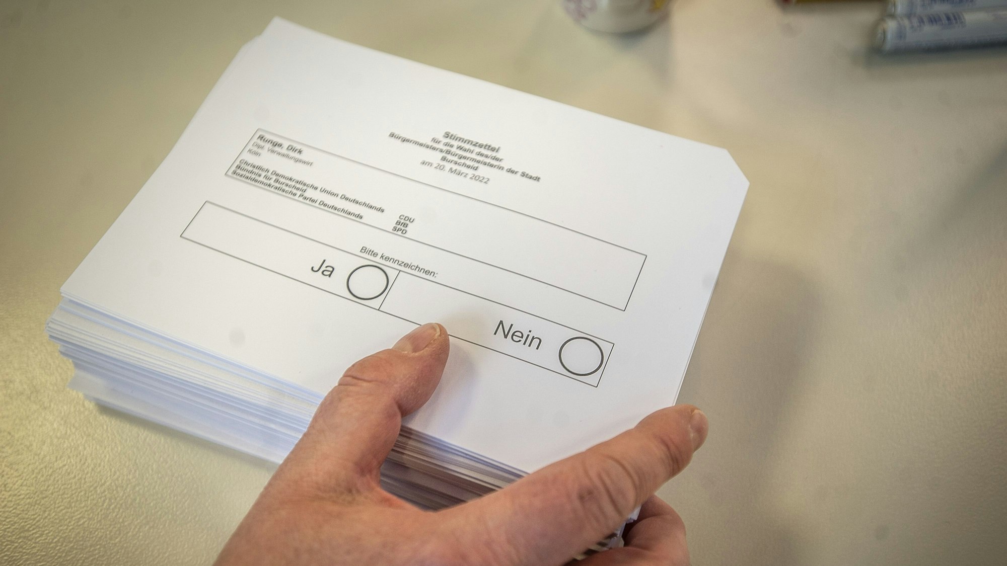 Ein Stapel Wahlzettel liegt auf einem Tisch.
