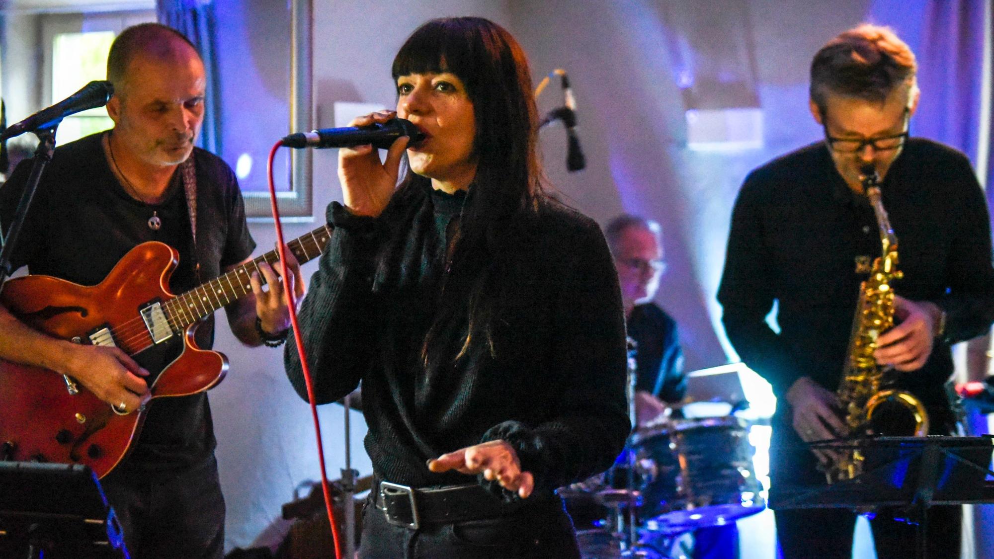 Zu sehen ist Sängerin Nina Anders mit ihrer Band beim Auftritt.