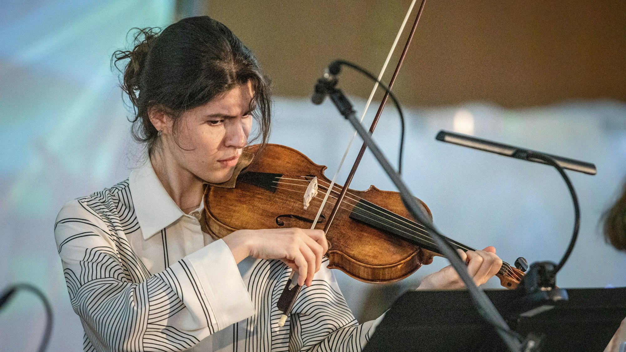 Musikerin Ekaterina Perlina steht in einem weißen Oberteil mit ihrer Violine bei einem Konzert der Kammermusik aus dem 18. Jahrhundert im Veranstaltungsaal Ventana.