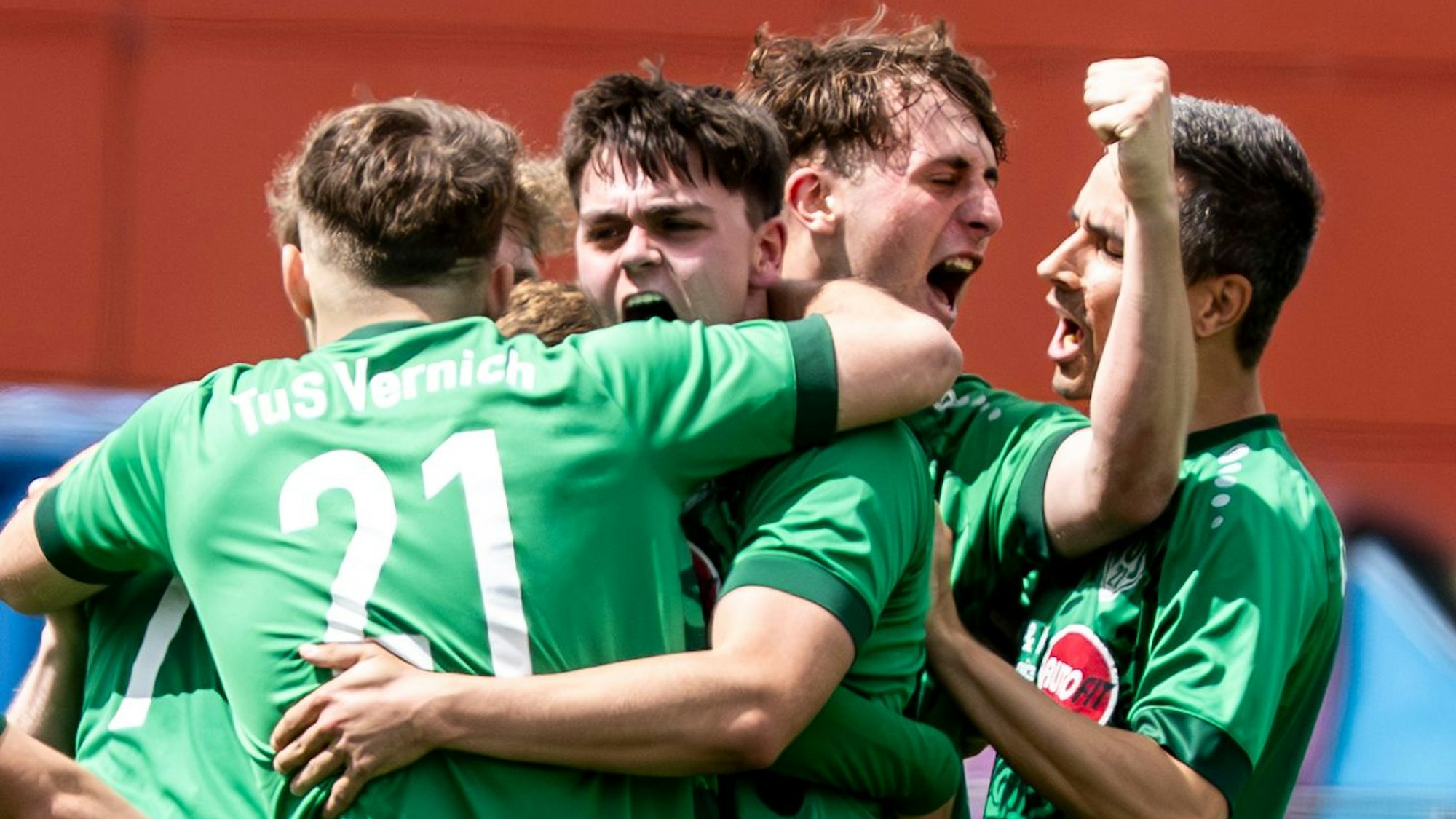 Spieler des TuS Vernich liegen sich jubelnd in den Armen.