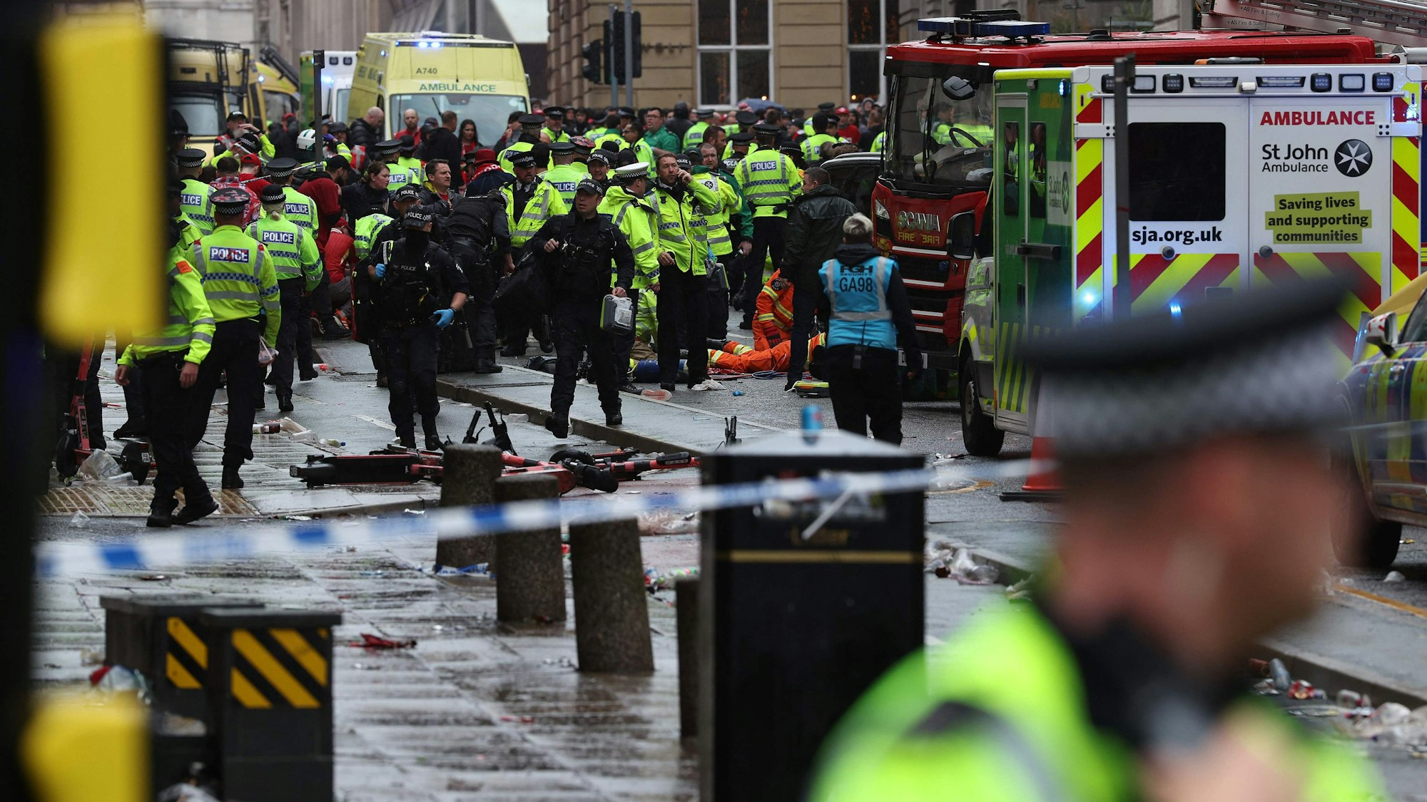 Members of the emergency services treat members of the public inside a Police cordon at the scene of an incident, on the sidelines of an open-top bus victory parade for Liverpool's Premier League title win, in Liverpool, north-west England on May 26, 2025. (Photo by Darren Staples / AFP)
