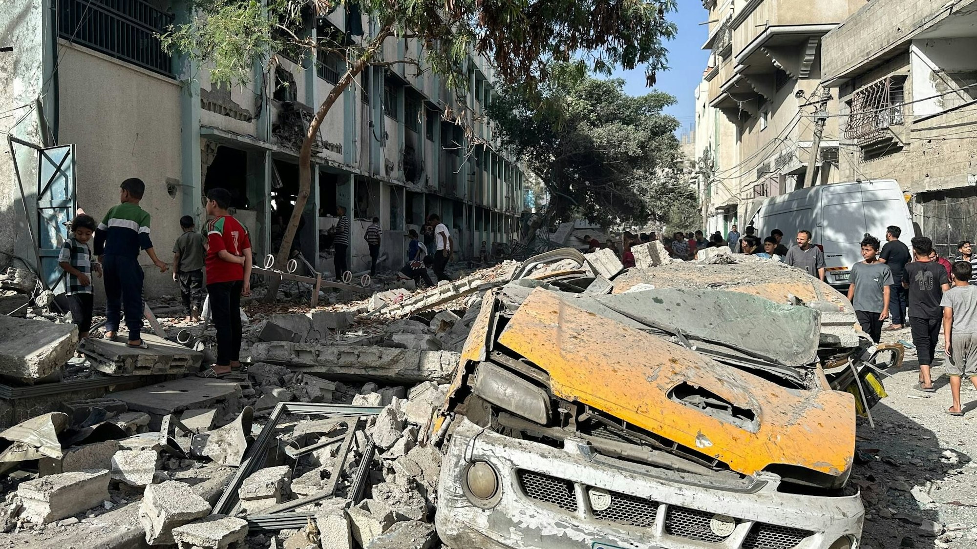 Zivilisten stehen im Staub nach einem israelischen Luftangriff auf eine Schule im Gazastreifen. /Khasan Alzaanin