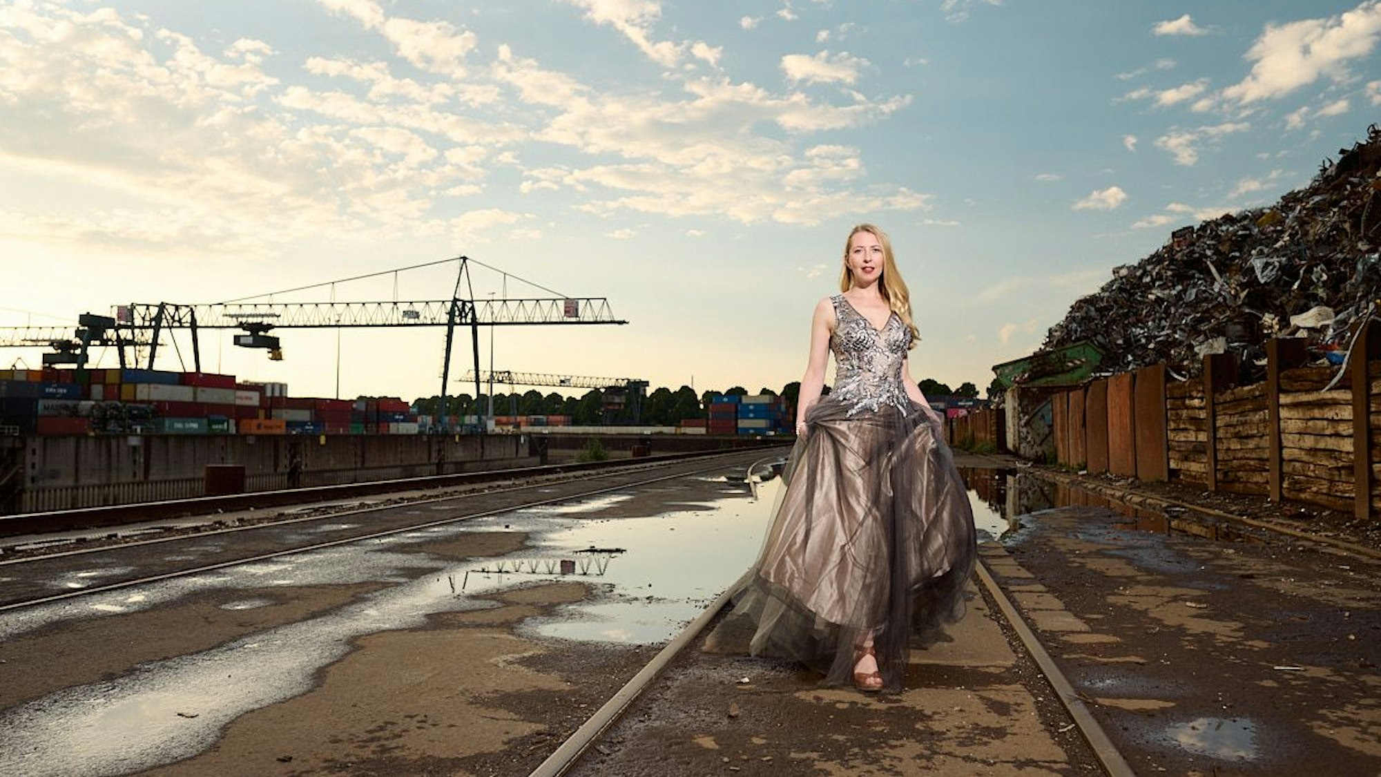 Die Kölner Sopranistin Agnes Lipka posiert zwischen Containerbahnhof und Schrottplatz