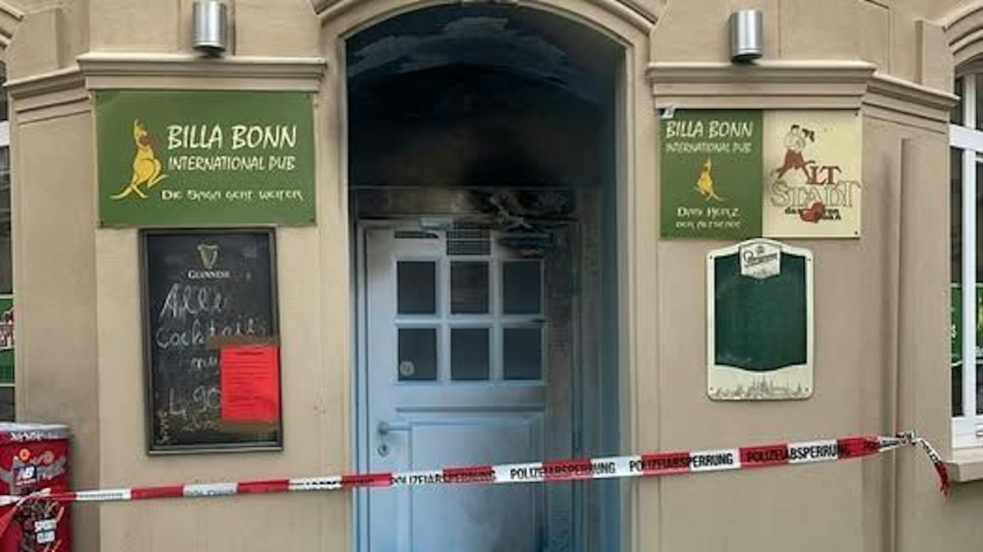 Die Eingangstür zum Billa Bonn mit Spuren des Brandes.