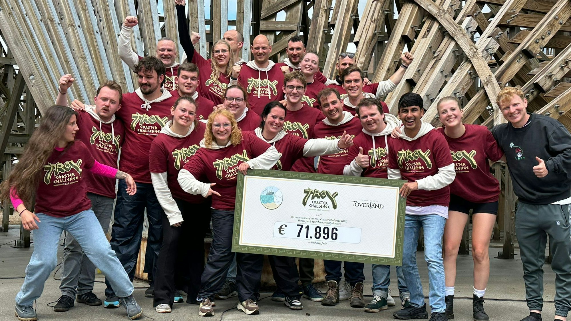 Zu sehen ist eine Gruppe von Leuten, die einen symbolischen Scheck halten.