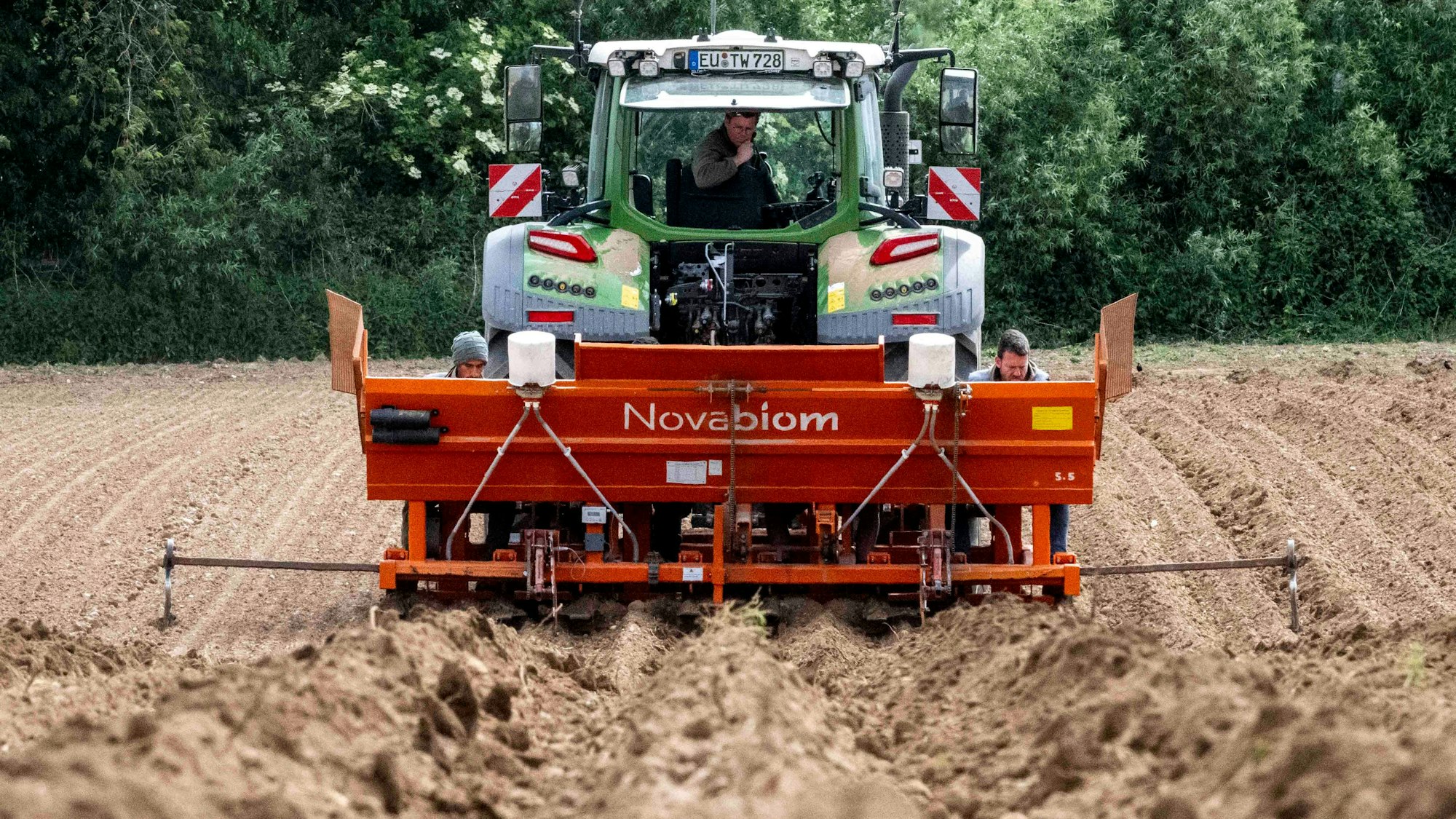 Das Bild zeigt einen Traktor, der auf einem Feld unterwegs ist.