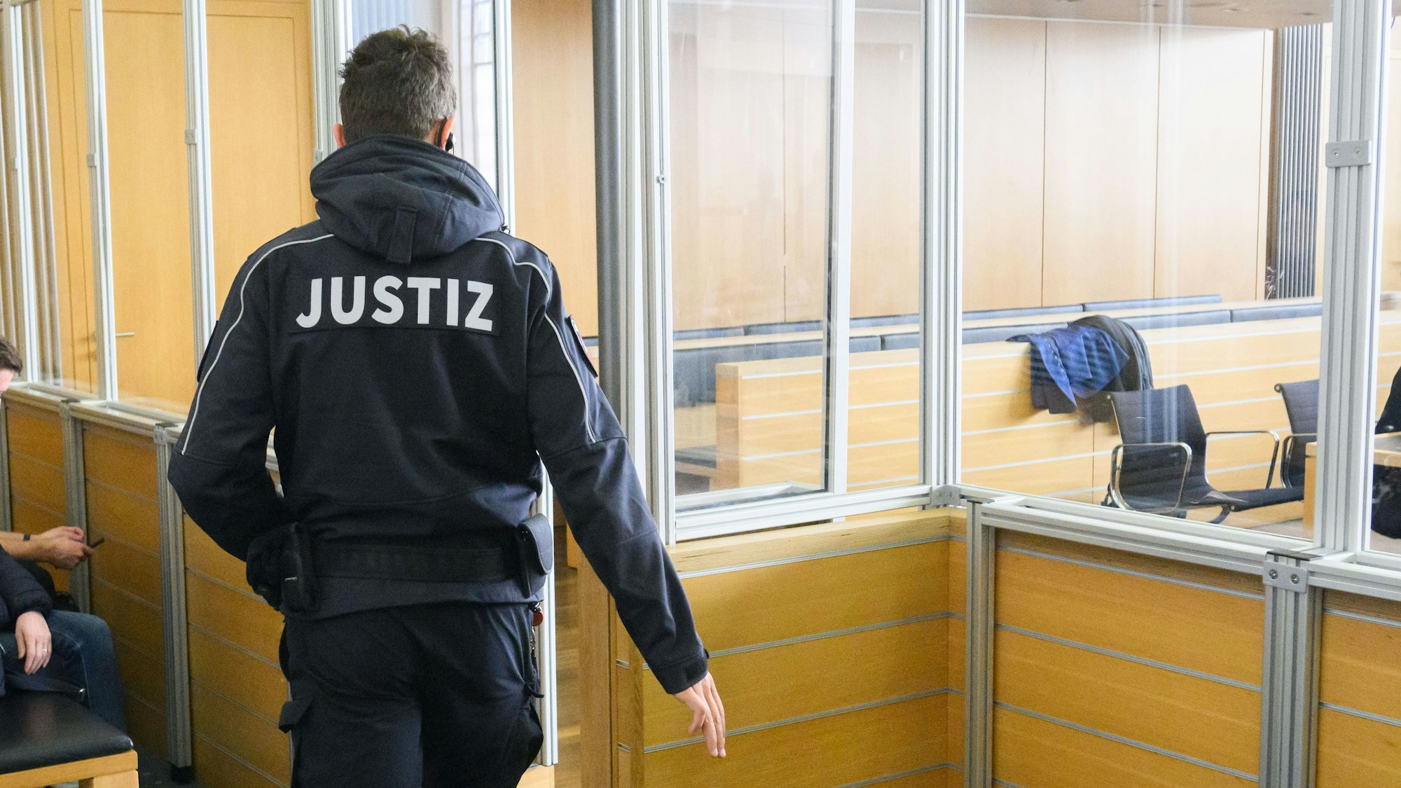 Ein Justizbeamter beaufsichtigt den Prozess gegen die Ex-VW-Manager im Landgericht Braunschweig.