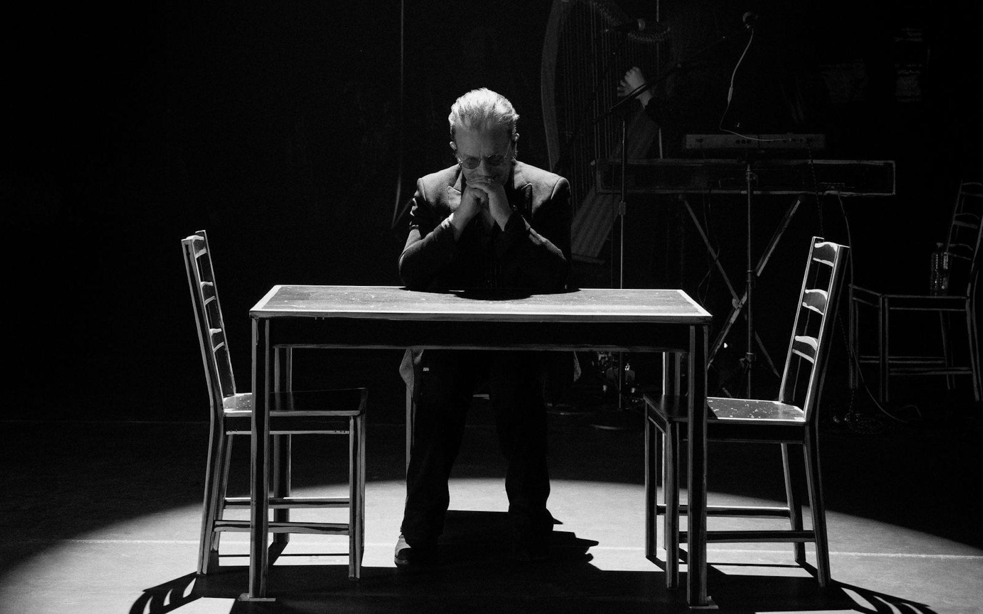 Ein Tisch und drei Stühle reichen: Anders als bei den aufwendigen Bühnenshows mit U2 setzt Bono bei seinen Solo-Auftritten auf Minimalismus. (Bild: Apple)
