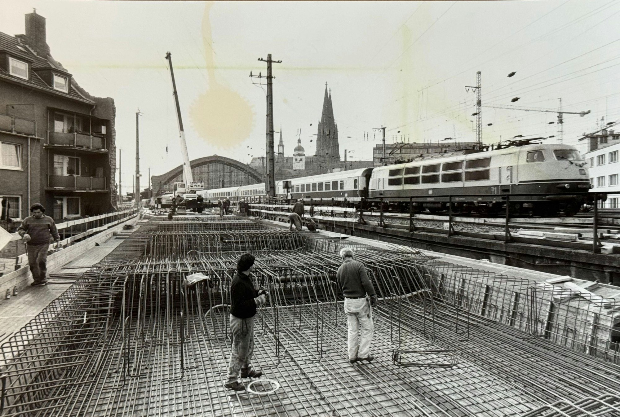 07.04.1987, Köln: Arbeiten am Stahlbeton sind zwischen Hauptbahnhof und Hansaring im Gange während rechts ein Eisenbahnzug vorbei fährt. Der Bereich wird um ein weiteres Gleis für die S-Bahn erweitert. Foto: Walter Schiestel