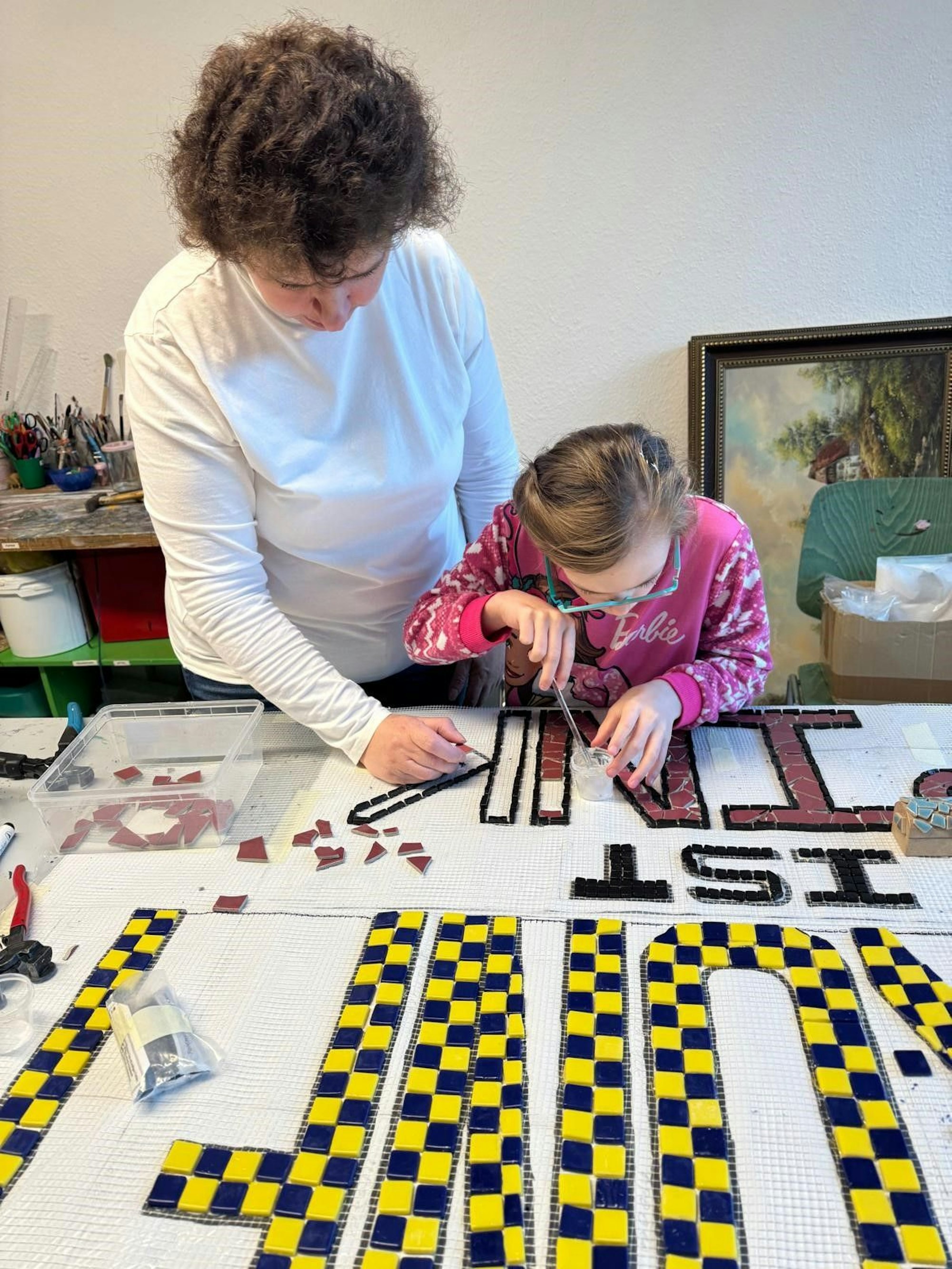 Mosaik-Künstlerin Laura Sinayski in Aktion mit einer Besucherin der OT Ohmstraße.