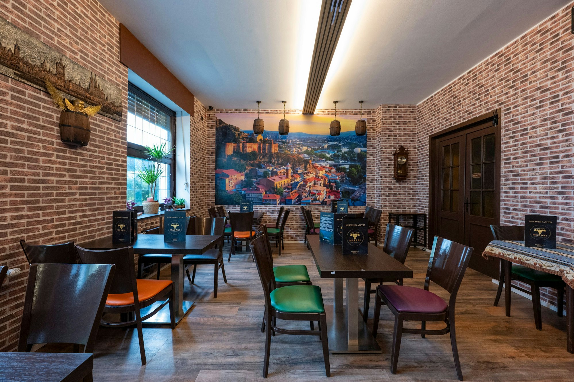 Das Interieur des Lokals ist zu sehen, an der Wand eine Aufnahme von Tiflis.