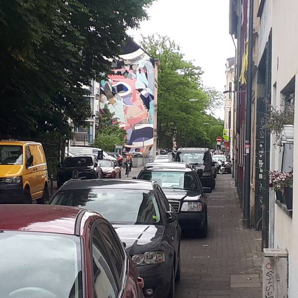 Ein Gehweg ist fast komplett von Autos zugeparkt.