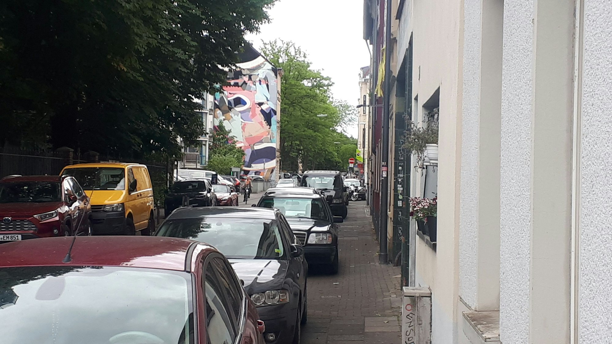 Ein Gehweg ist fast komplett von Autos zugeparkt.