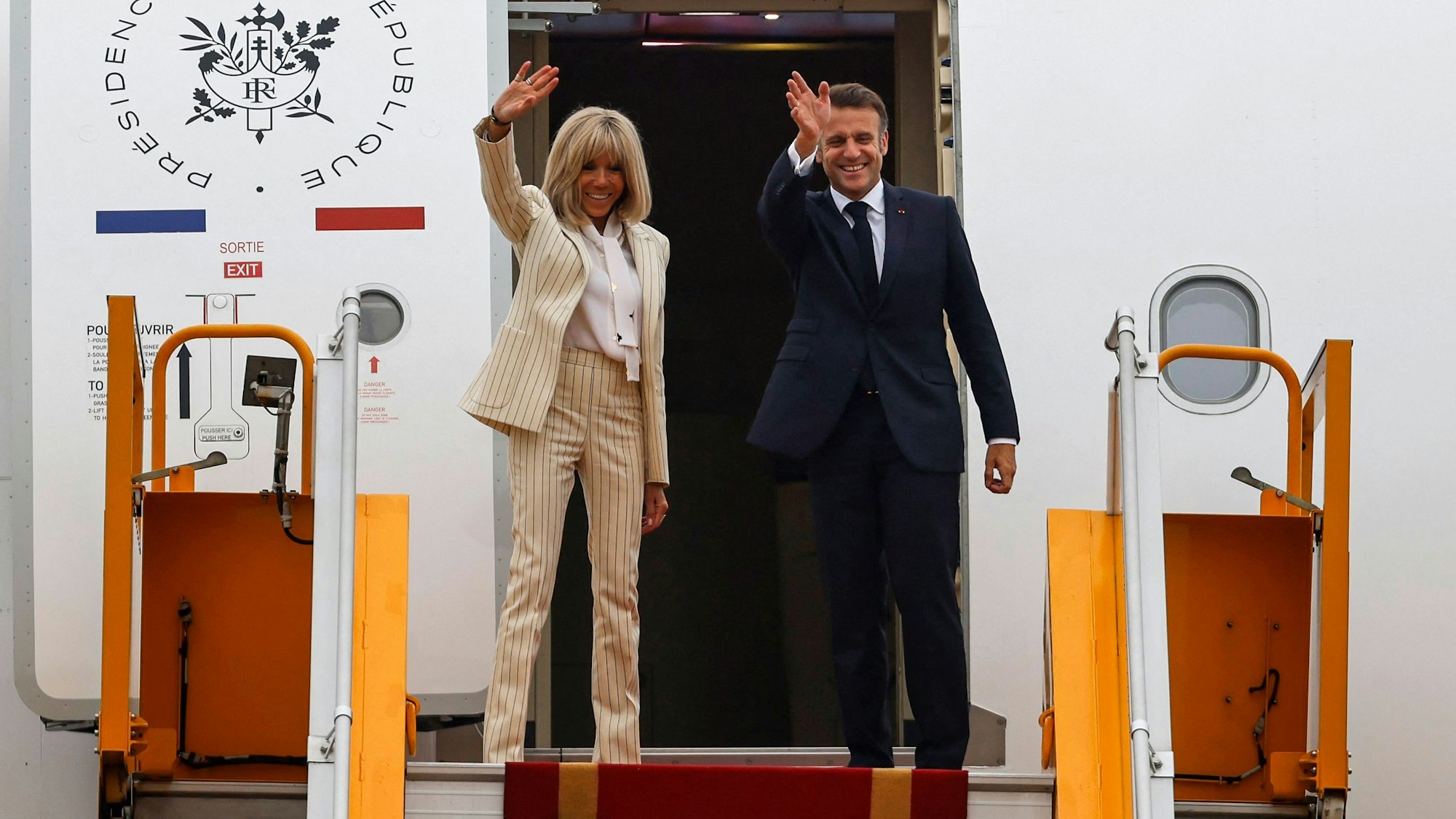 Präsident Emmanuel Macron und seine Frau Brigitte Macron winken, als sie am internationalen Flughafen Noi Bai in Hanoi ihr Flugzeug zum Abflug nach ihrem Vietnambesuch besteigen.