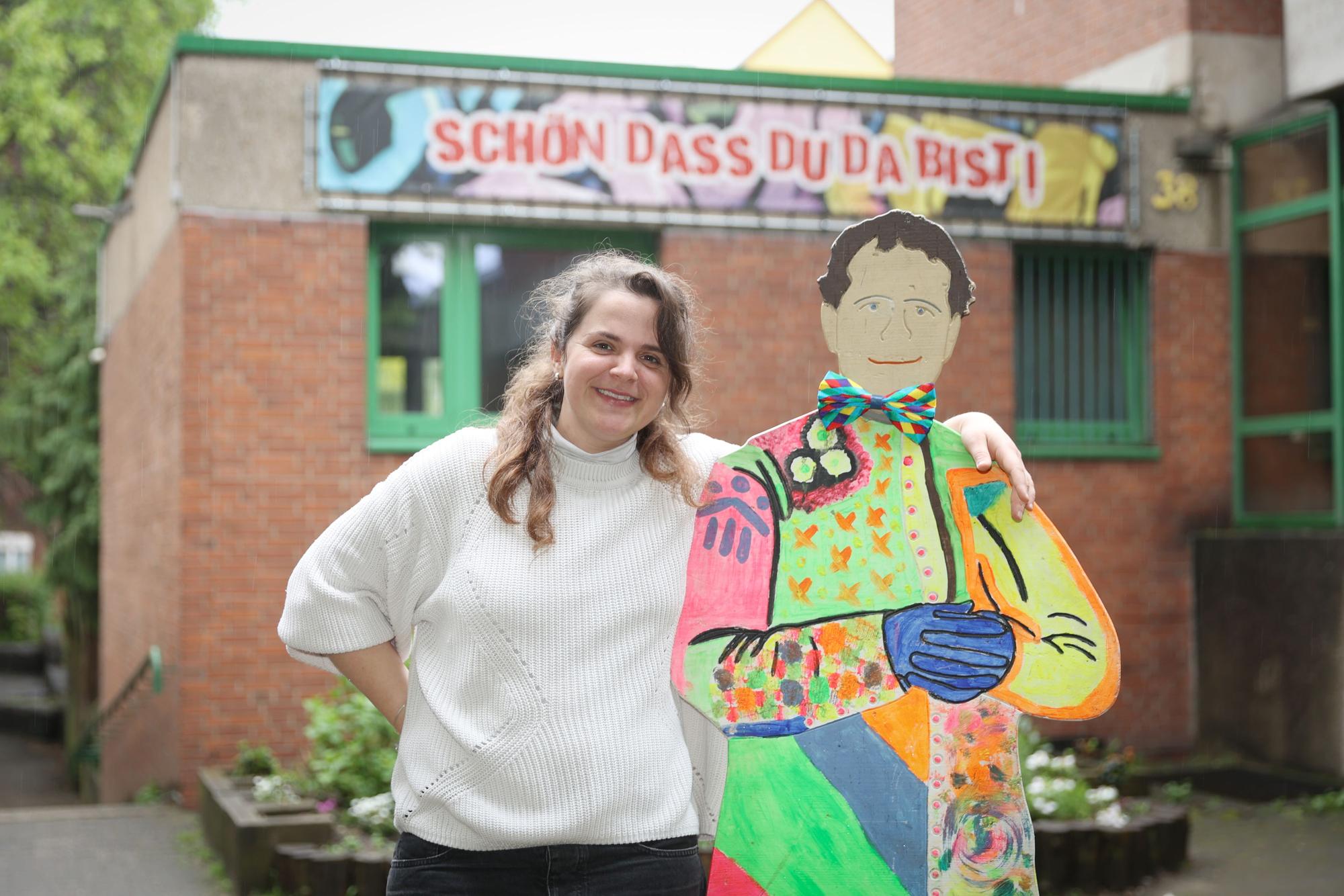 Die Leiterin des Don-Bosco-Clubs in Mülheim Magdalena Keil umarmt eine Pappfigur des Namensgebers der Jugendeinrichtung.