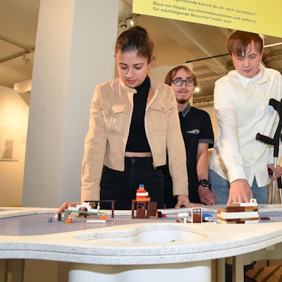 Kinder schauen auf ein, mit Lego bebautes Feld.