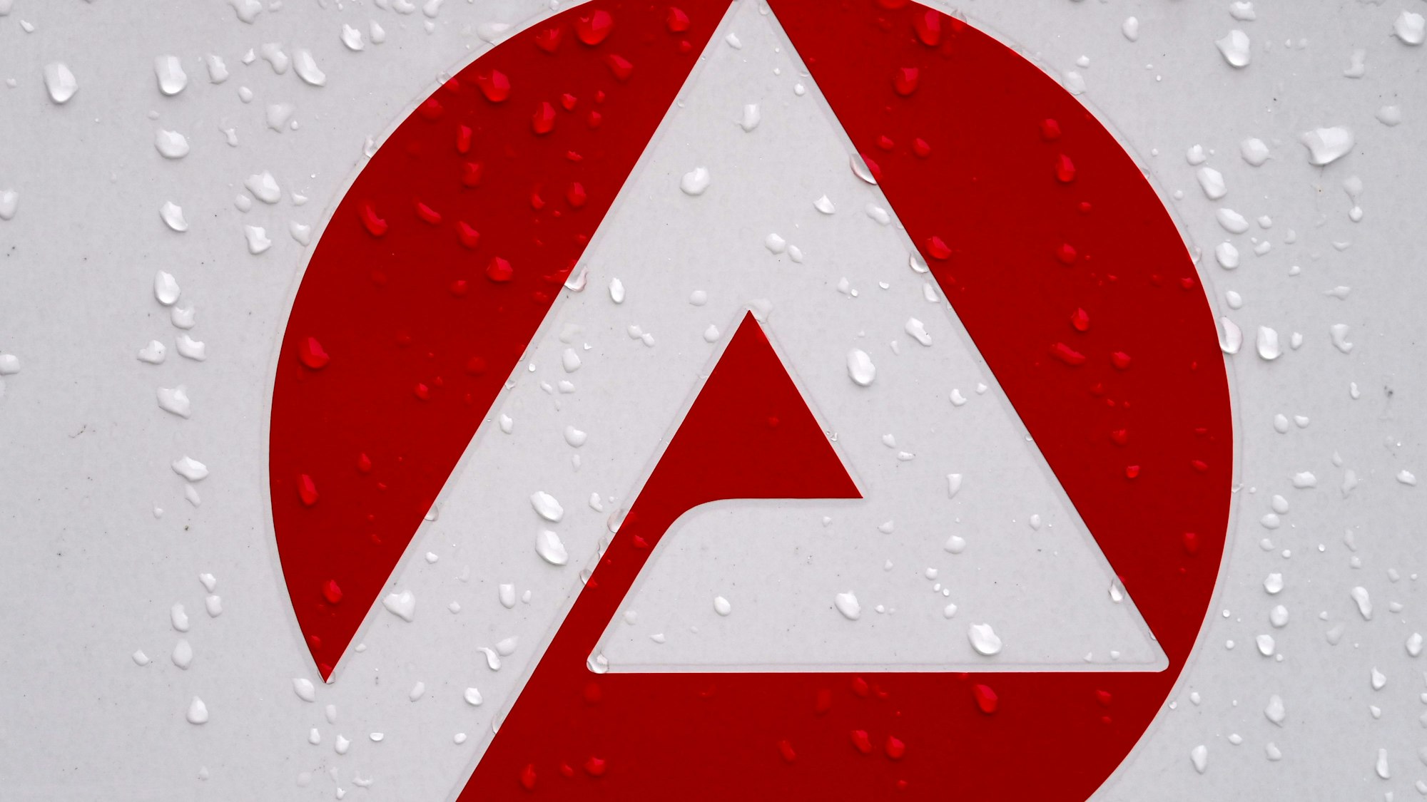 Regentropfen perlen vom Logo der Agentur für Arbeit ab.