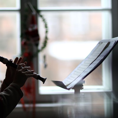 Das Foto zeigt einen Musikschüler, der auf einer Blockflöte spielt.