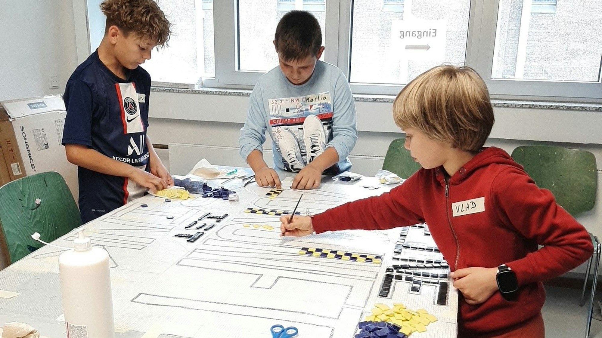 Kinder arbeiten an einem Mosaik beim von„ wir helfen“ geförderten Bildungsprojekt „Pink“ in der OT Ohmstraße.