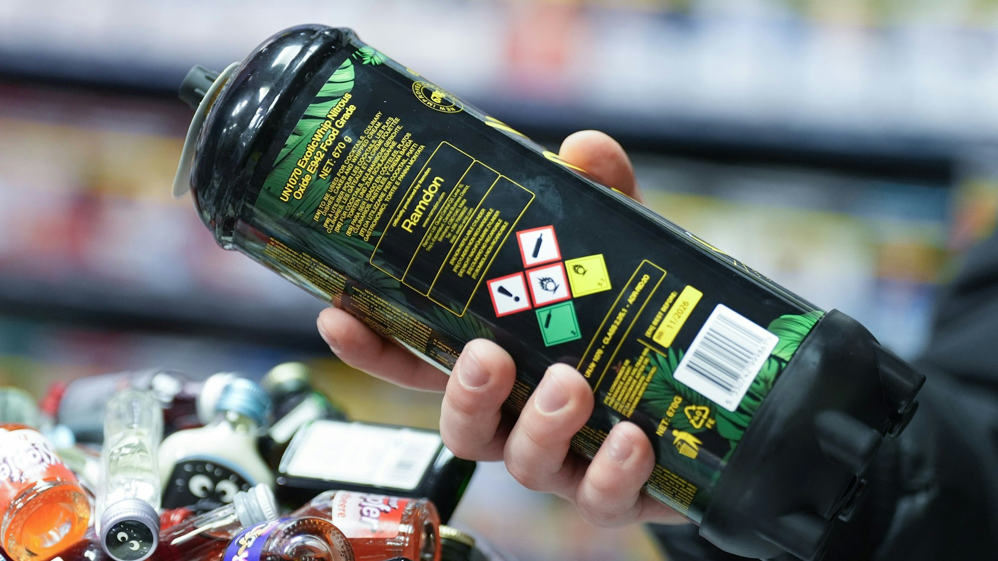 Das Symbolbild zeigt eine Lachgasdose in der Hand eines Mannes.