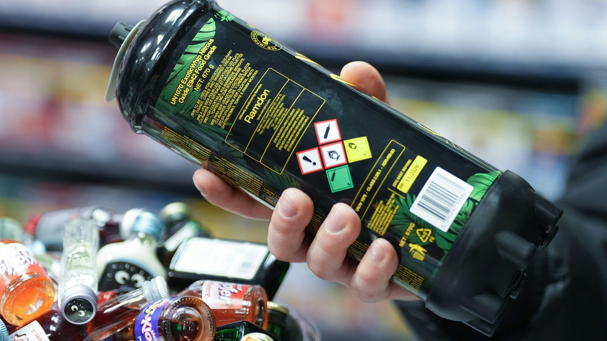 Ein Mitarbeiter hält eine Dose Lachgas am Tresen eines Kiosks in der Hand.(Symbolbild)