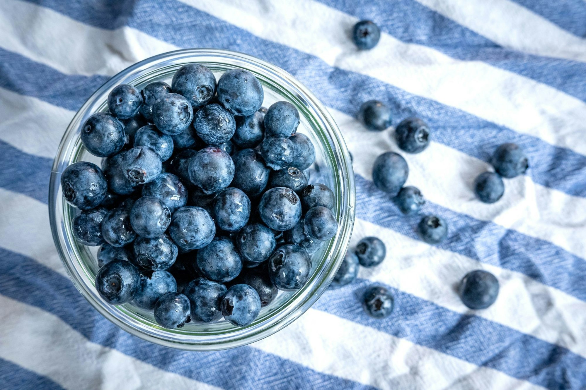 Beeren statt Chips oder Nüsschen: Heidelbeeren, auch Blaubeeren genannt, liegen auf einem Esstisch und werden gern gesnackt.