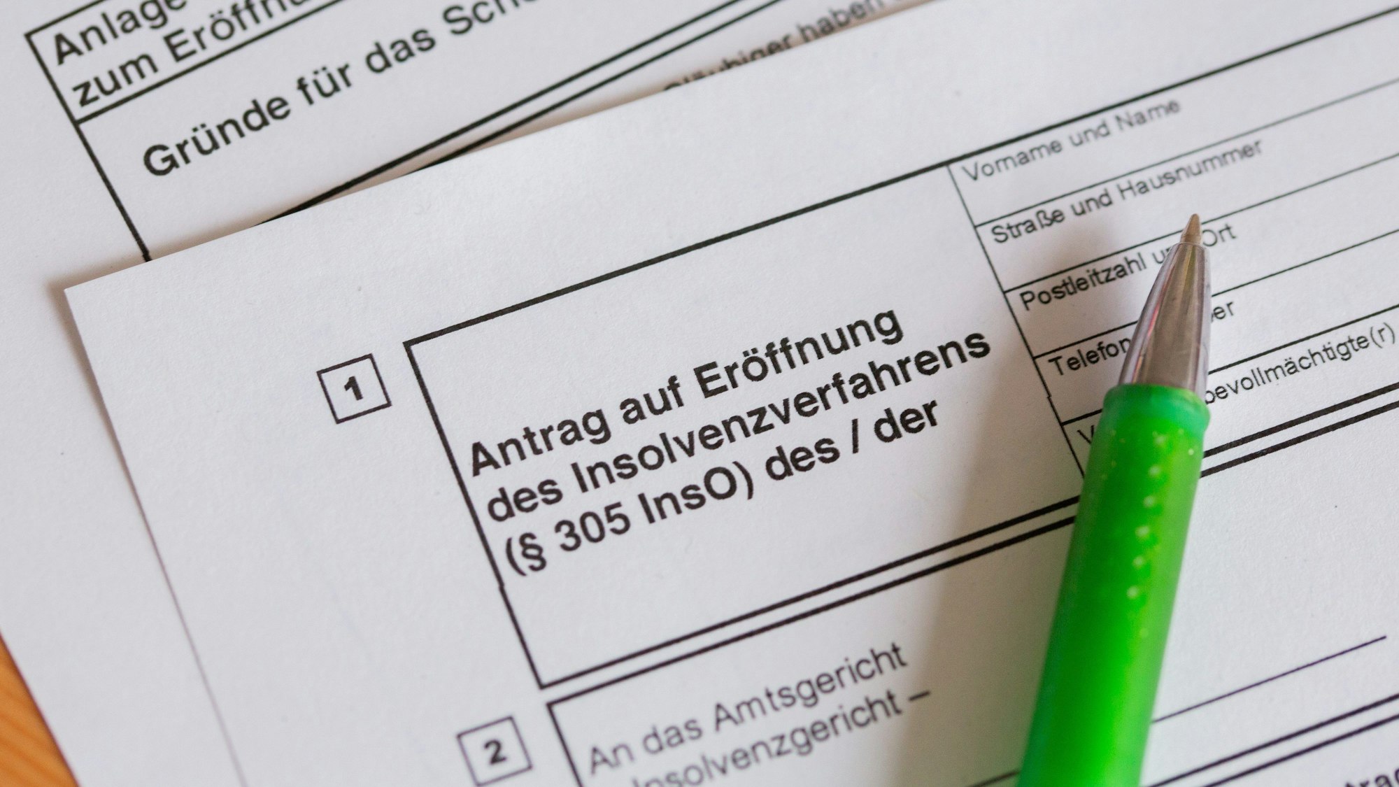 Ein Kugelschreiber liegt auf einem Antrag zur Eröffnung eines Insolvenzverfahrens.