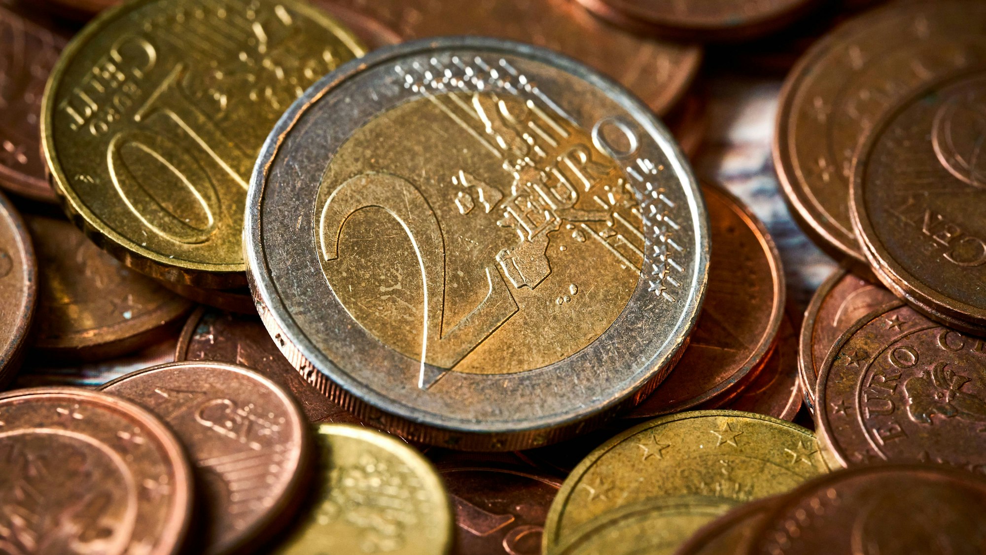 Eine Zwei-Euro-Münze neben anderen Münzen (Symbolfoto).