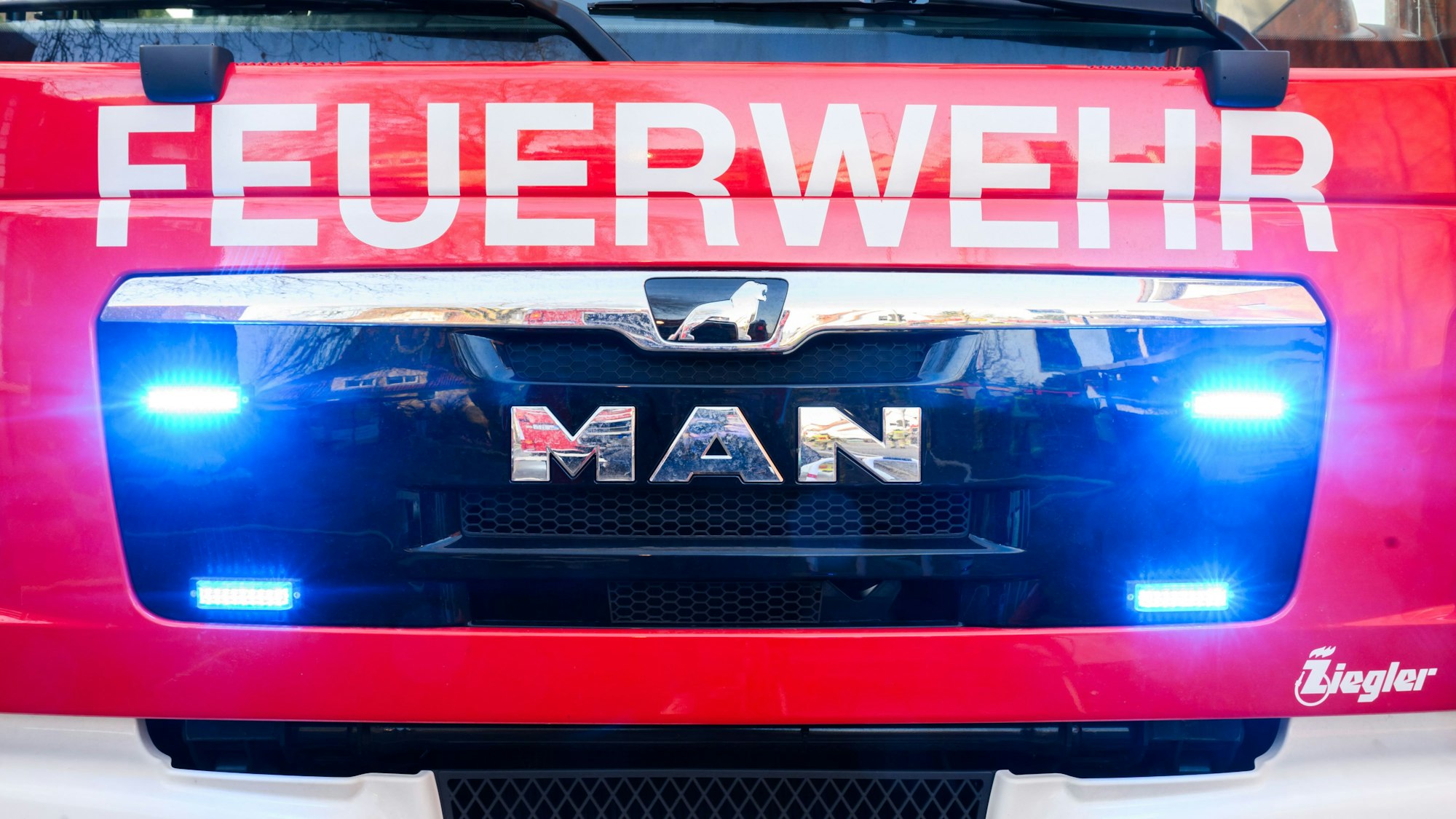 Blaulichter leuchten an einer Einsatzstelle an einem Löschfahrzeug der Feuerwehr.