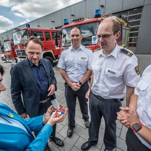 Leverkusen verkauft mehrere Feuerwehrwagen an die Hilfsorganisation Blau-Gelbes Kreuz. Das Land NRW zahlt auch den Transport. Linda Mai, Blau-Gelbes Kreuz, nimmt die Schlüssel in Empfang von Oberbürgermeister Uwe Richrath, von der Feuerwehr sind dabei: Thomas Kresse, Martin Gäde und Robin Wagner.