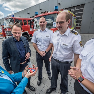Leverkusen verkauft mehrere Feuerwehrwagen an die Hilfsorganisation Blau-Gelbes Kreuz. Das Land NRW zahlt auch den Transport. Linda Mai, Blau-Gelbes Kreuz, nimmt die Schlüssel in Empfang von Oberbürgermeister Uwe Richrath, von der Feuerwehr sind dabei: Thomas Kresse, Martin Gäde und Robin Wagner.
