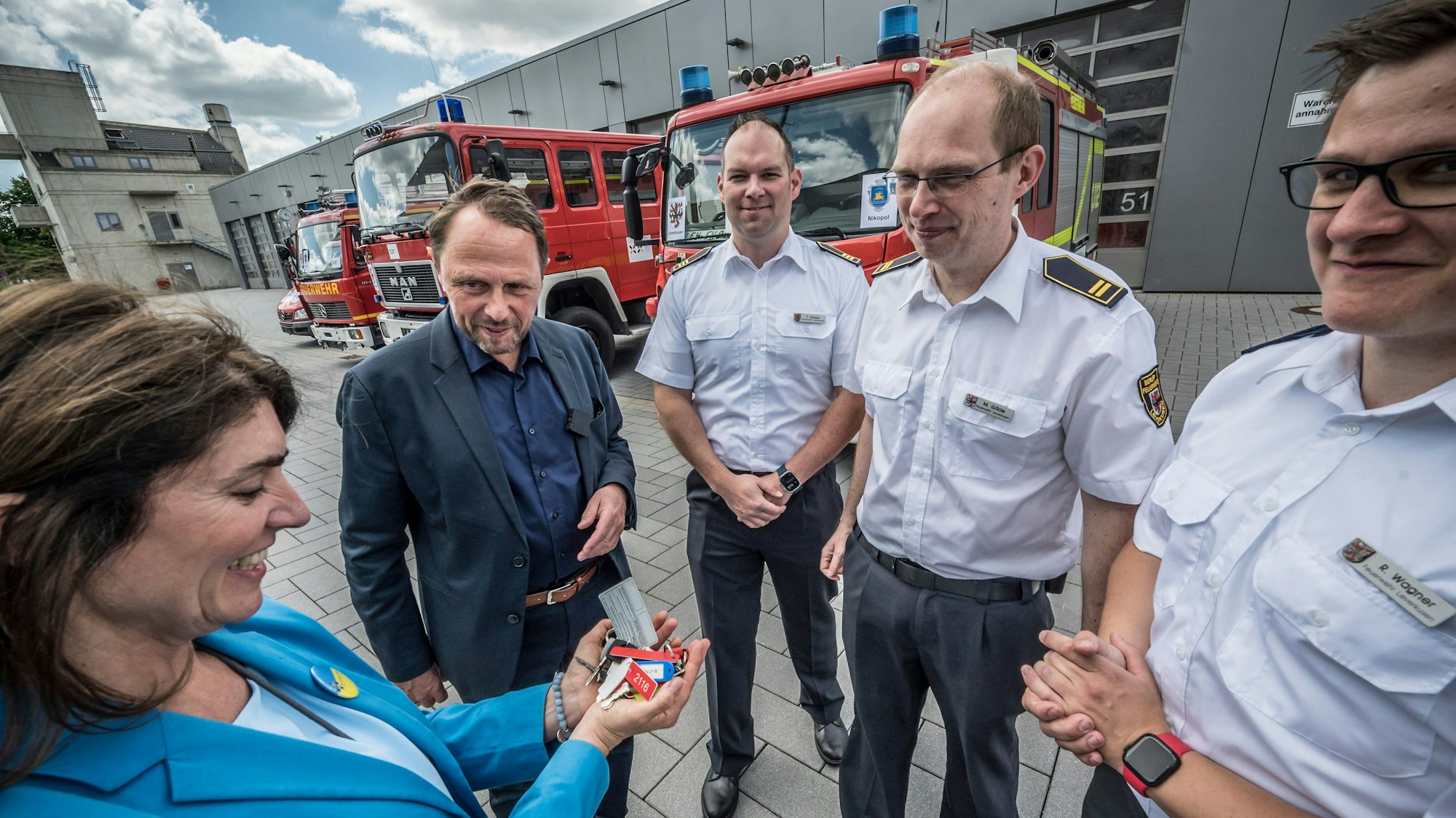 Leverkusen verkauft mehrere Feuerwehrwagen an die Hilfsorganisation Blau-Gelbes Kreuz. Das Land NRW zahlt auch den Transport. Linda Mai, Blau-Gelbes Kreuz, nimmt die Schlüssel in Empfang von Oberbürgermeister Uwe Richrath, von der Feuerwehr sind dabei: Thomas Kresse, Martin Gäde und Robin Wagner.